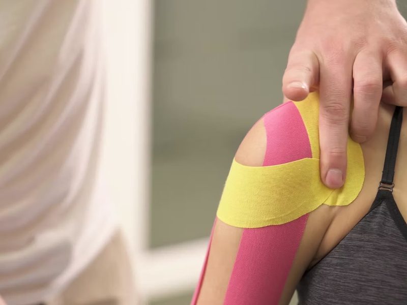Pose de bandes de kinésio-taping par le physiothérapeute
